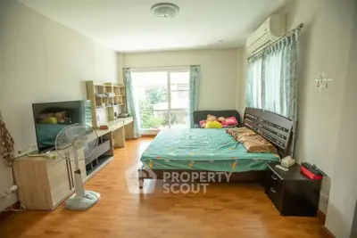 Spacious bedroom with large window and modern furnishings, ideal for comfort and relaxation.