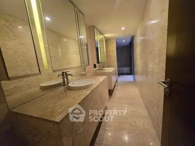 Luxurious marble bathroom with dual sinks and modern lighting