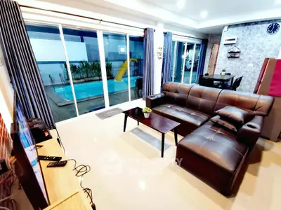 Luxurious living room with pool view, modern leather sofa, and sleek decor in a contemporary home.
