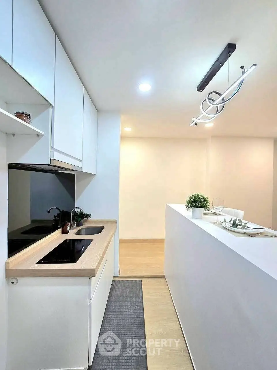 Modern kitchen with sleek design and open layout, featuring stylish lighting and minimalist decor.