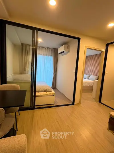 Modern apartment interior with two cozy bedrooms and stylish living area, featuring elegant lighting and wooden flooring.