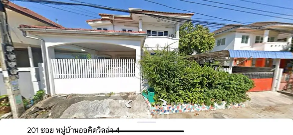Charming suburban house with lush greenery and spacious driveway in a peaceful neighborhood.