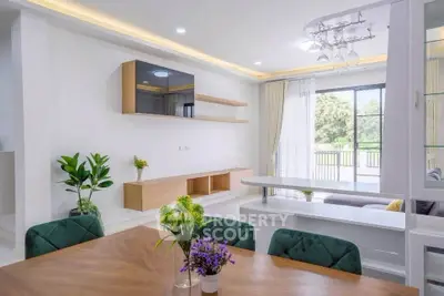 Modern open-plan living room with elegant dining area and large windows.