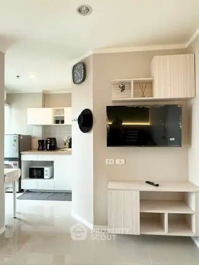 Modern living room with open kitchen, sleek TV setup, and stylish decor.