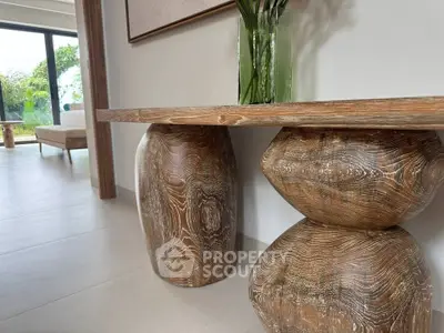 Elegant modern interior with unique wooden furniture and large windows offering natural light.