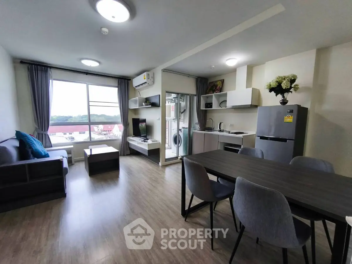 Modern open-plan living room with kitchen, dining area, and large window view.