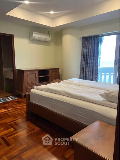 Spacious bedroom with ocean view and elegant wooden flooring