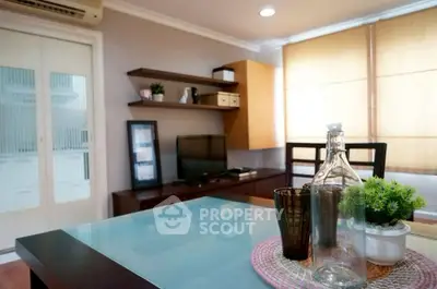 Stylish living room with modern decor and glass table in cozy apartment.