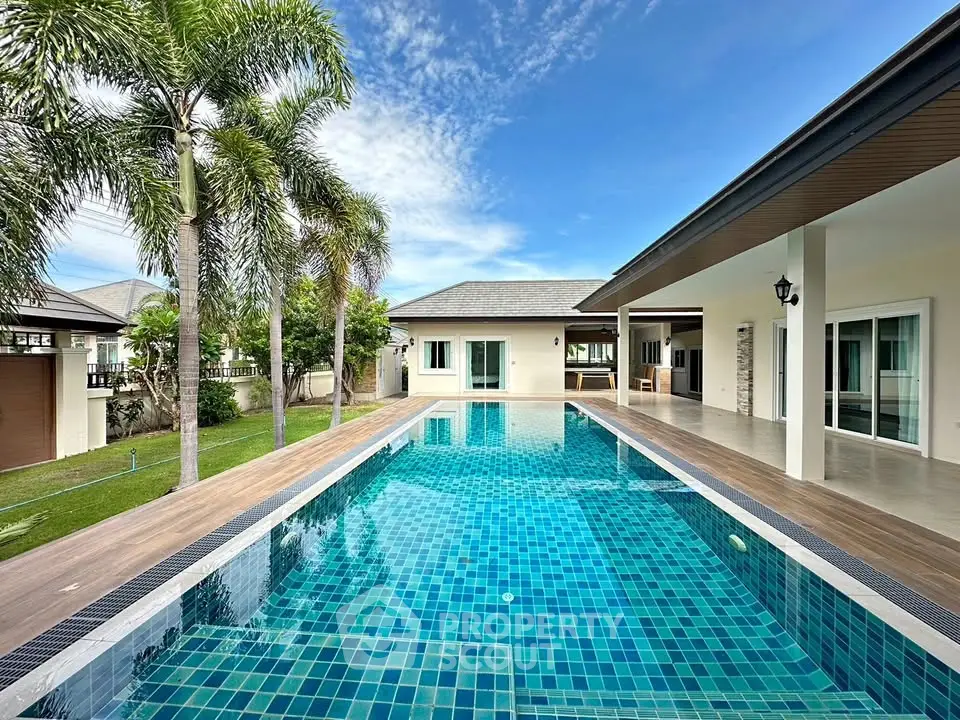 Luxurious villa with stunning pool and palm trees, perfect for tropical living.