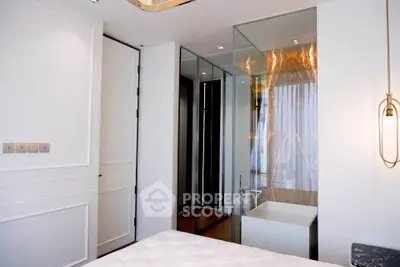 Luxurious modern bedroom with glass-enclosed bathtub and elegant lighting