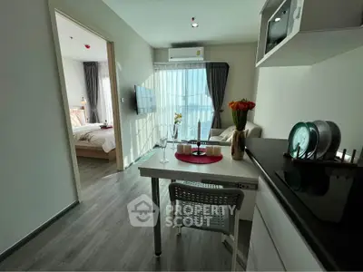 Modern open-plan apartment with stylish kitchen and cozy bedroom, featuring abundant natural light and sleek design.