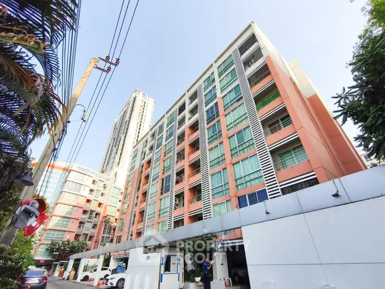 Modern urban apartment building with vibrant facade and clear blue sky.