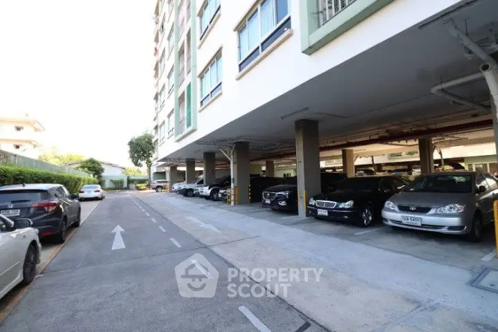Spacious covered parking area in modern residential building with ample parking spaces.