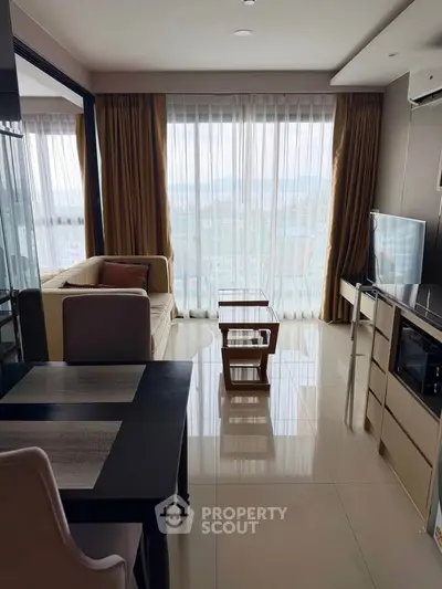 Modern living room with large windows and scenic view, featuring stylish furniture and open layout.