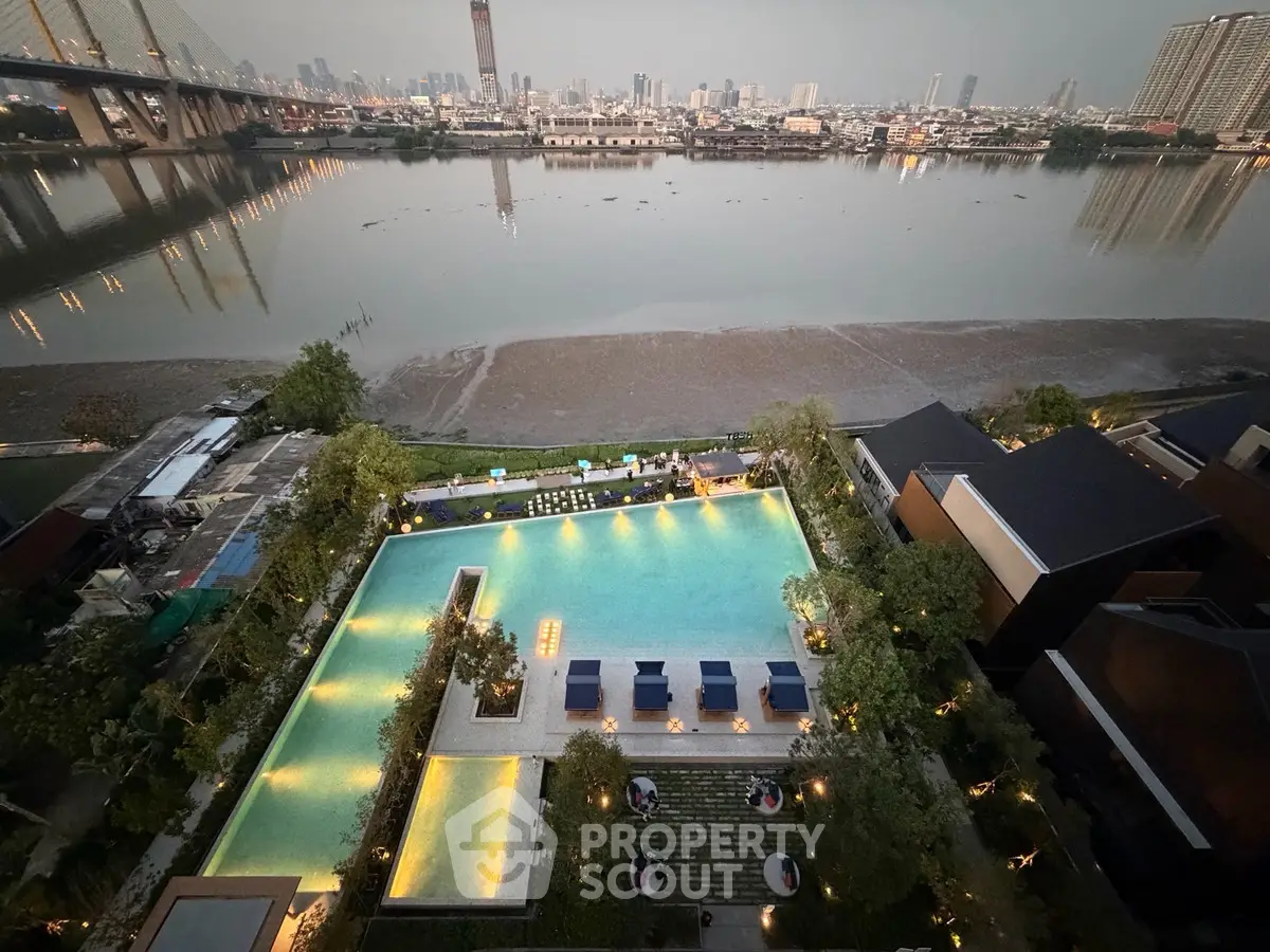 Stunning riverside view with illuminated pool and city skyline at dusk