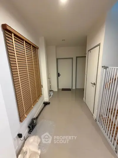 Spacious hallway with modern design and wooden blinds, perfect for a welcoming entrance.