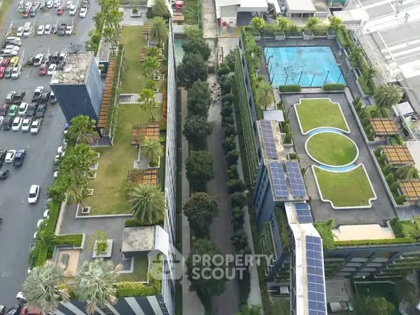 Aerial view of modern urban complex with rooftop gardens and pool area.