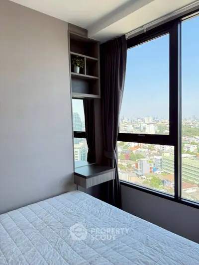Modern bedroom with large window offering stunning city view, featuring sleek built-in shelves and elegant curtains.