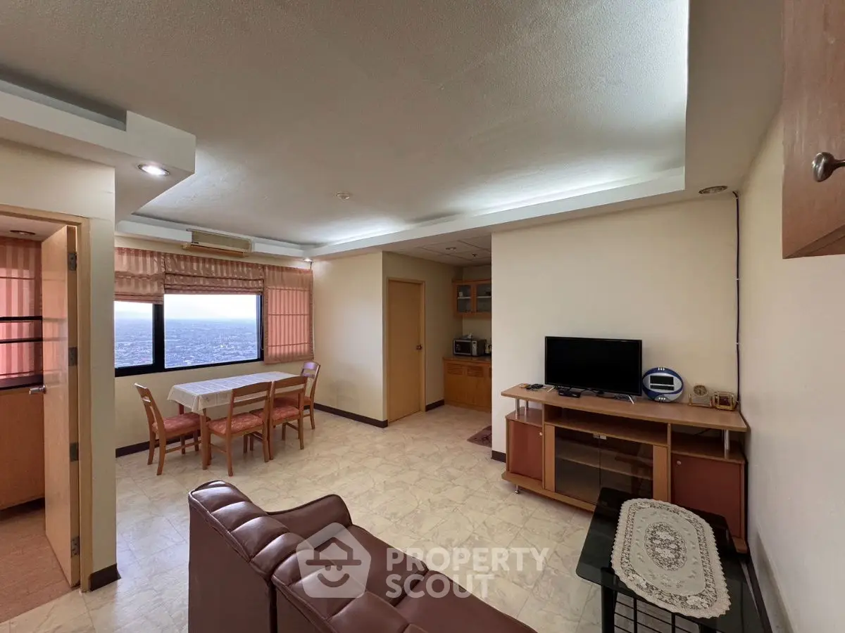Spacious living room with dining area and city view, perfect for modern living.