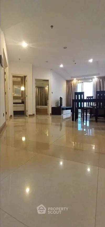 Spacious modern living room with glossy tiled floors and elegant dining area.
