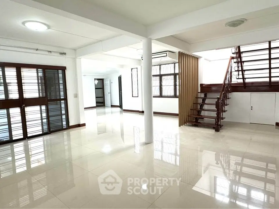 Spacious open-plan living area with modern staircase and large windows