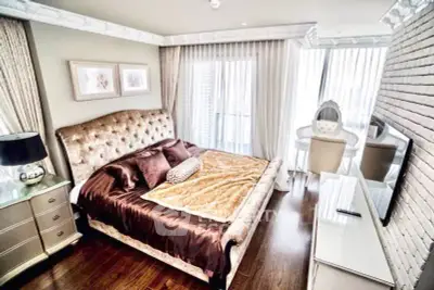Luxurious bedroom with elegant decor and large windows offering natural light.