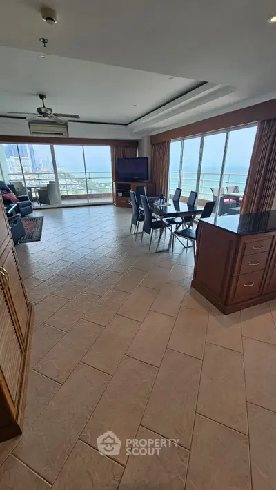 Spacious living room with ocean view and elegant dining area in luxury apartment.
