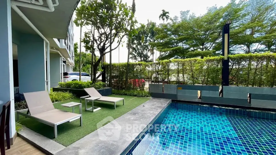 Luxurious outdoor pool area with sun loungers and lush greenery, perfect for relaxation.