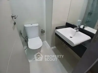 Compact modern bathroom with sleek fixtures and minimalist design.