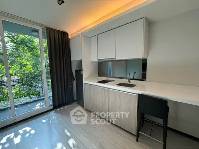 Modern kitchen with sleek cabinetry and balcony view