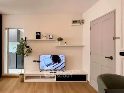 Modern living room with TV, wooden flooring, and minimalist decor