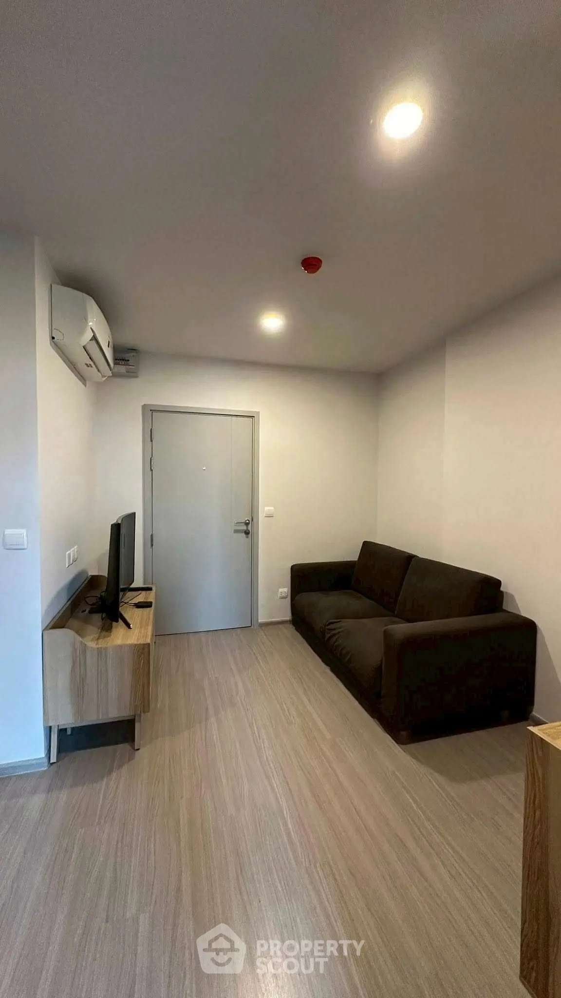 Modern living room with sleek design, featuring a comfortable sofa and wall-mounted TV, perfect for relaxation.