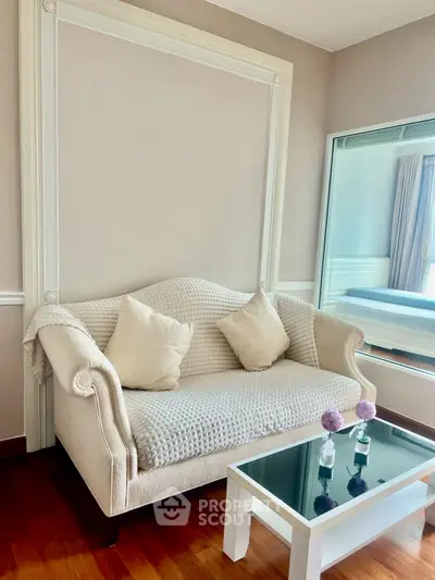 Elegant living room with cozy sofa and glass coffee table, perfect for relaxation.