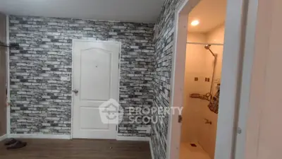 Chic apartment interior with modern brick accent wall and cozy bathroom.
