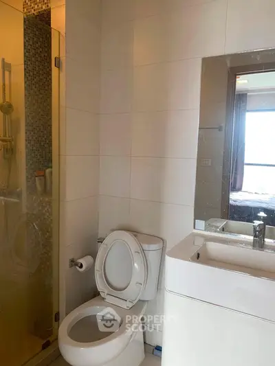 Modern bathroom with glass shower and sleek fixtures in a contemporary apartment.