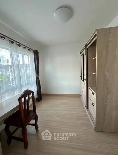 Spacious study room with wooden flooring and ample natural light