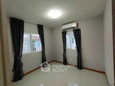 Spacious bedroom with large windows and modern air conditioning unit