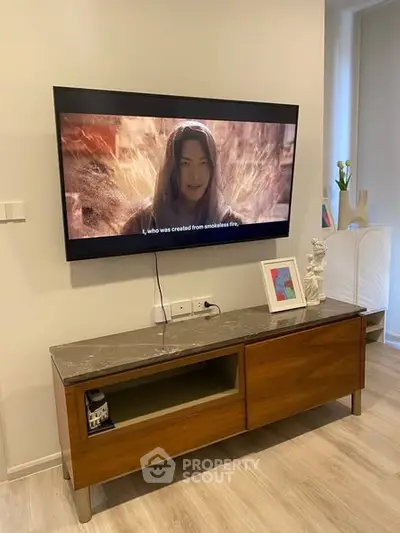 Modern living room with wall-mounted TV and stylish wooden console.