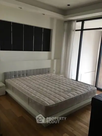 Spacious bedroom with modern design and large windows for natural light.