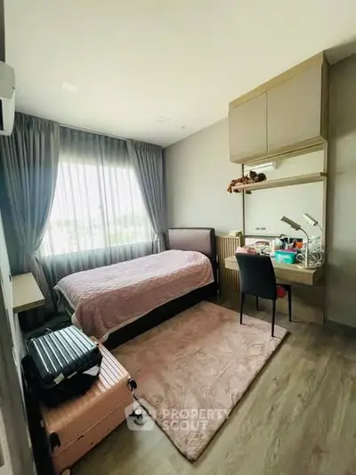 Cozy bedroom with modern decor, ample natural light, and stylish furnishings.