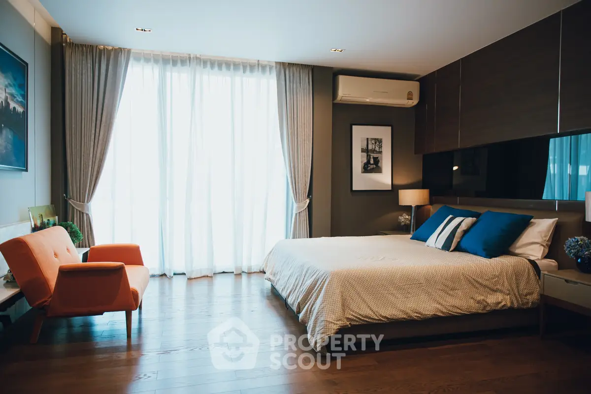 Luxurious bedroom with modern decor and large window for natural light.