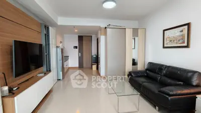 Modern living room with sleek furniture and open kitchen layout in stylish apartment.