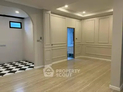 Elegant interior with classic wall paneling and checkered flooring in a spacious room.