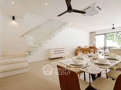 Spacious modern living room with elegant dining area and glass staircase, perfect for family gatherings.