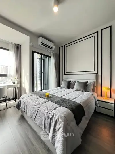 Modern bedroom with stylish decor and balcony view in a high-rise apartment.