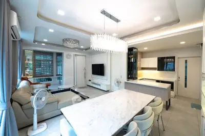 Luxurious open-plan living room and kitchen with elegant chandelier and modern furnishings.
