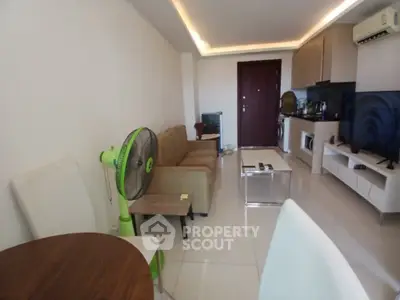 Modern living room with sleek furniture and open kitchen layout in a cozy apartment.