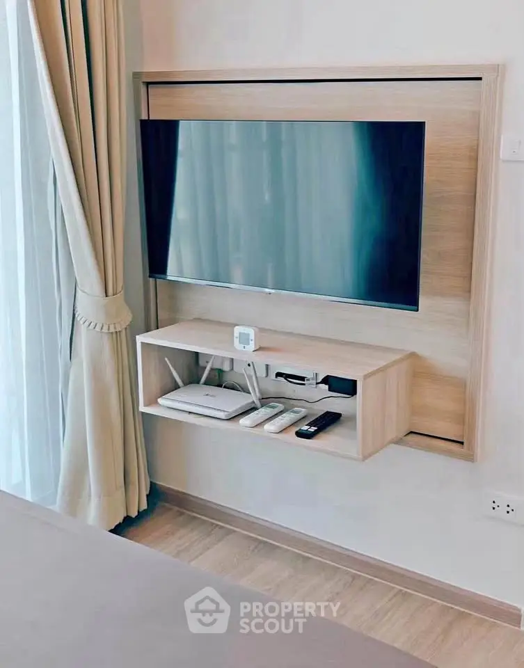 Modern living room with wall-mounted TV and elegant curtains, showcasing sleek interior design.