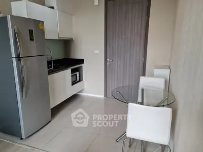 Modern kitchen with sleek appliances and dining area in stylish apartment