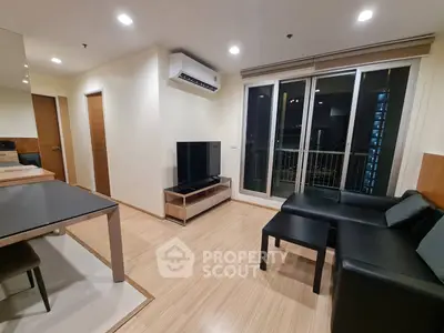 Modern living room with sleek furniture and balcony access in a stylish apartment.